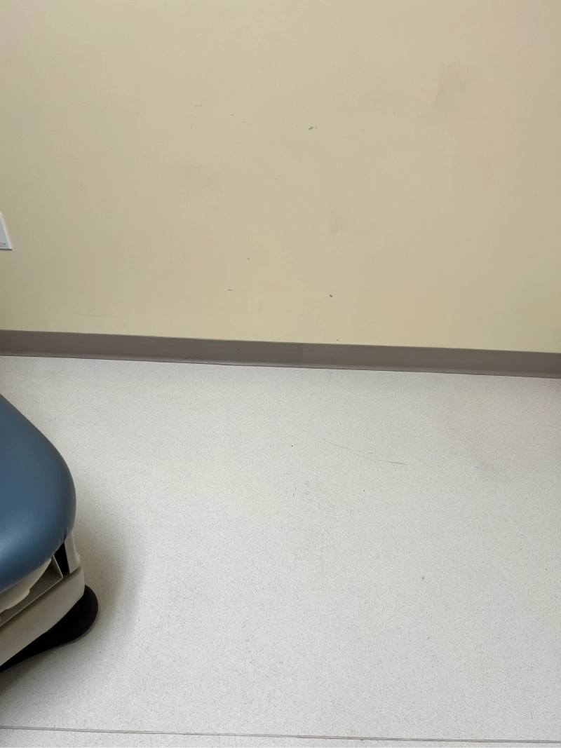 A motor scooter parked indoors near a beige wall.