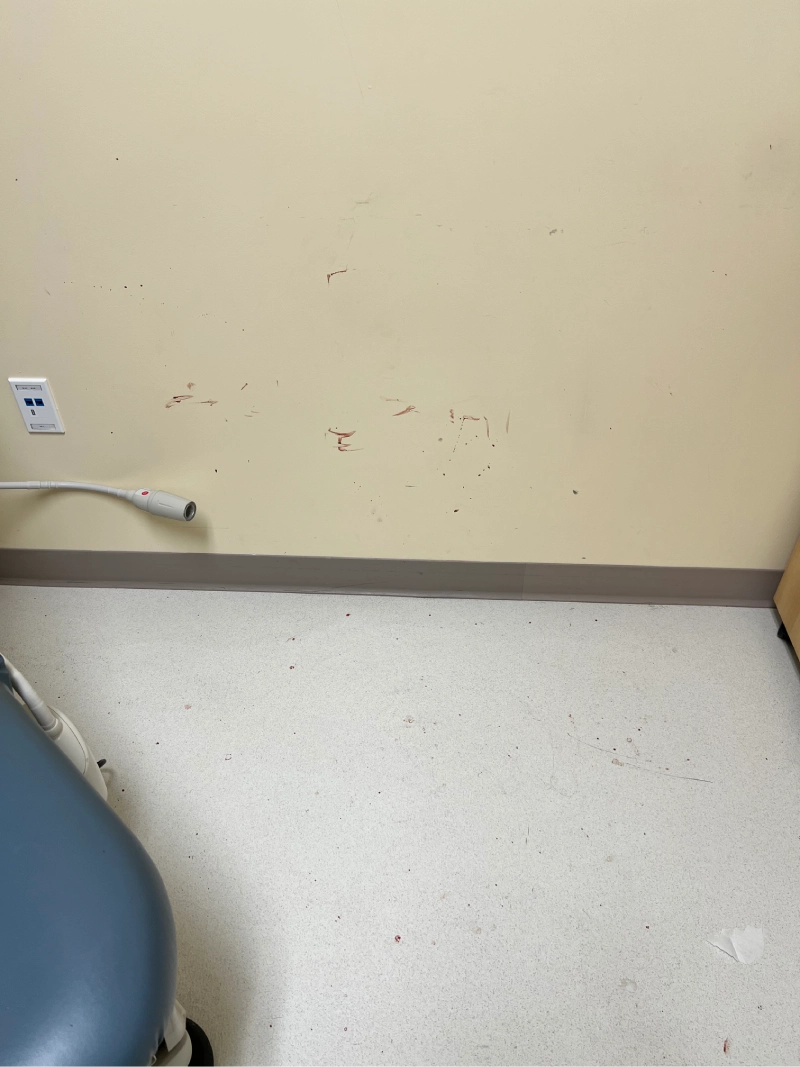 Empty corner of a room with a beige wall and white floor.
